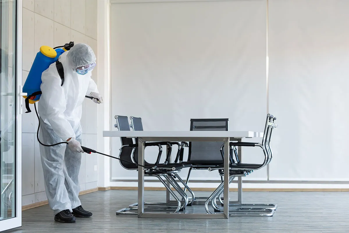 A professional disinfecting an office space.