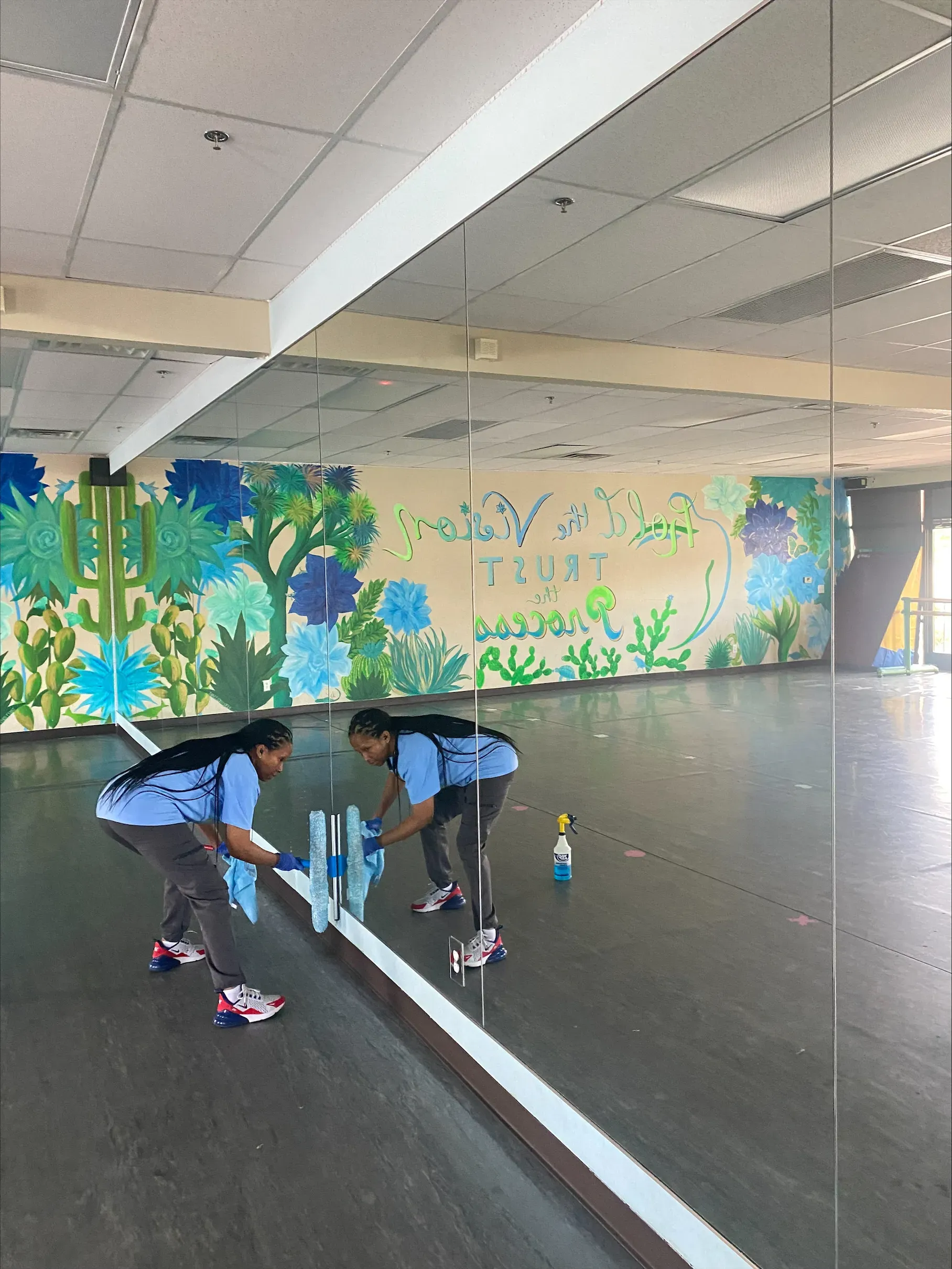 CitiClean Services cleaning technician cleaning the mirrors in a gym space in Las Vegas.