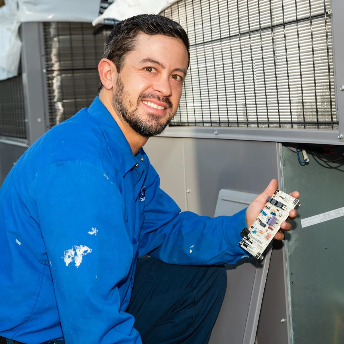 A technician from Evans Cool Solutions Inc working on an HVAC unit