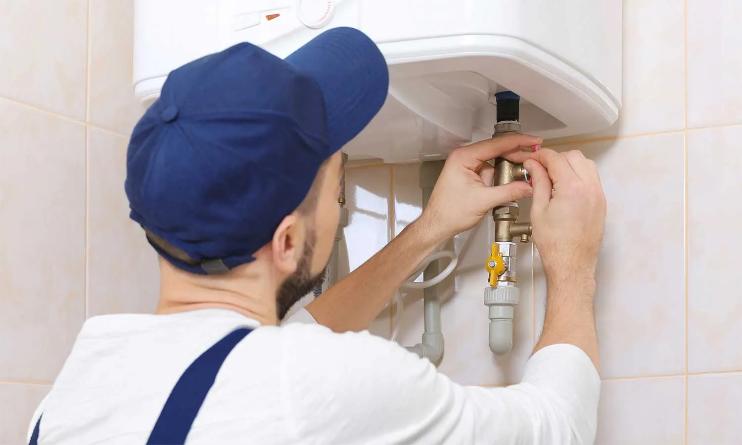 Professional plumber repairing a water heater in a residential setting in Palmdale