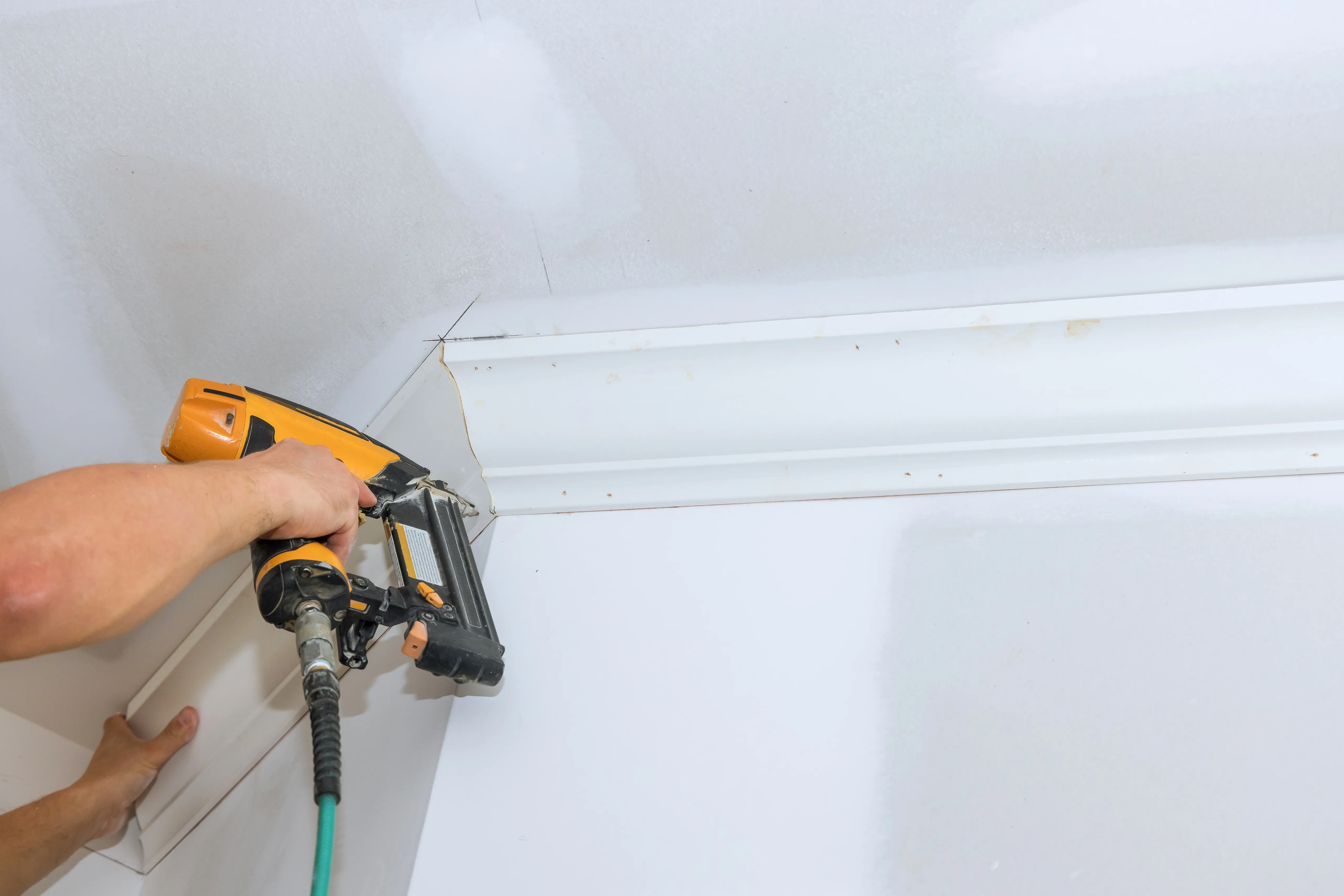 Skilled professional installing baseboard and crown molding in a Los Angeles home