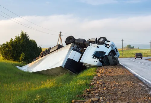 The truck lies in a ditch after the road accident.