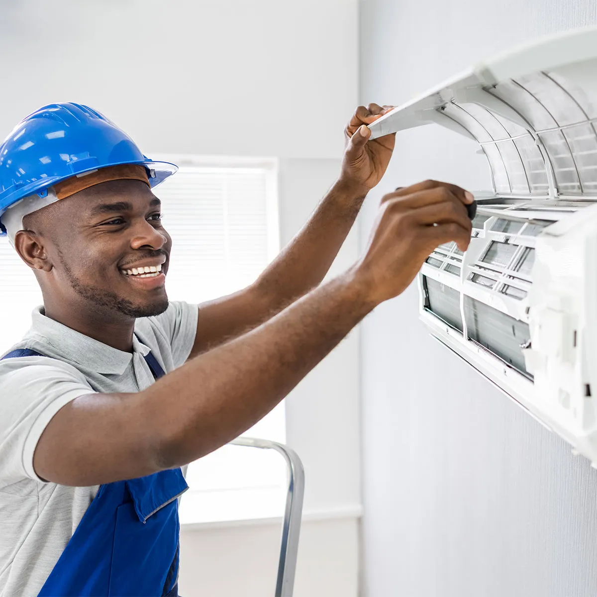 A professional HVAC technician repairing an AC unit.