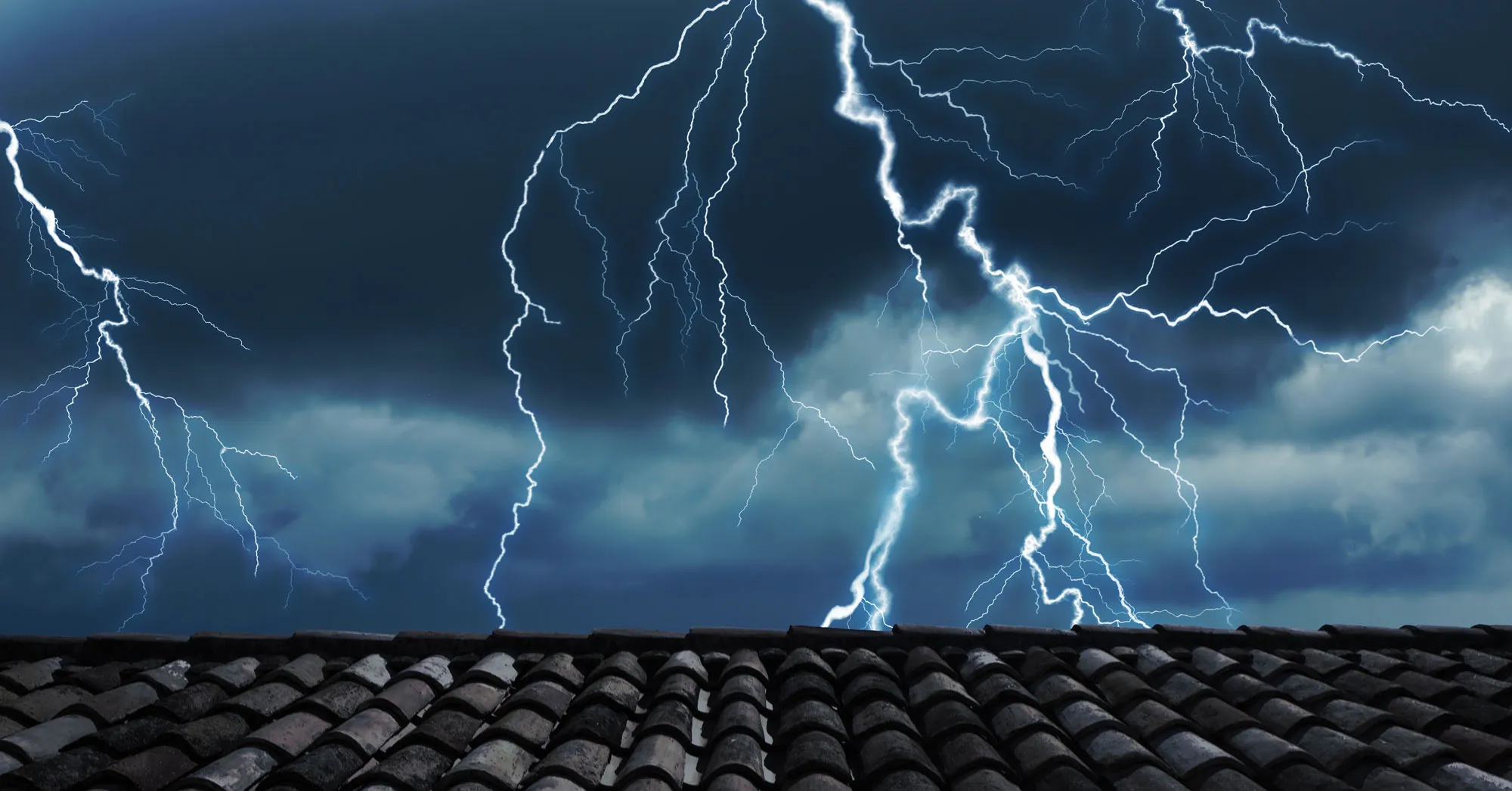 Lightning striking behind a roof.