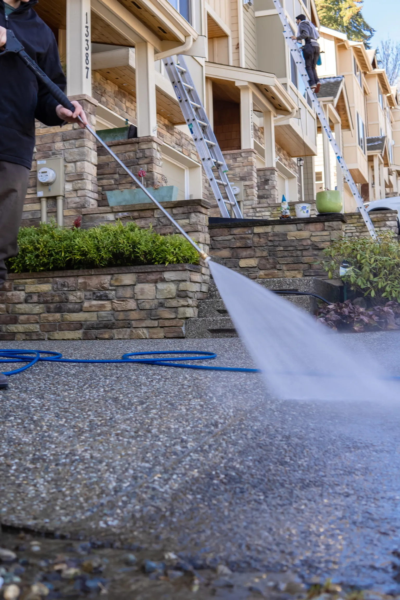 Pressure washing a driveway to remove dirt and grime.
