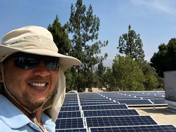 Solar panel cleaning project with Green Clean Window Cleaning and Services team member smiling.