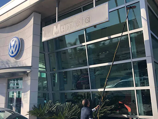 Commercial window cleaning using a water-fed pole in Corona, CA.