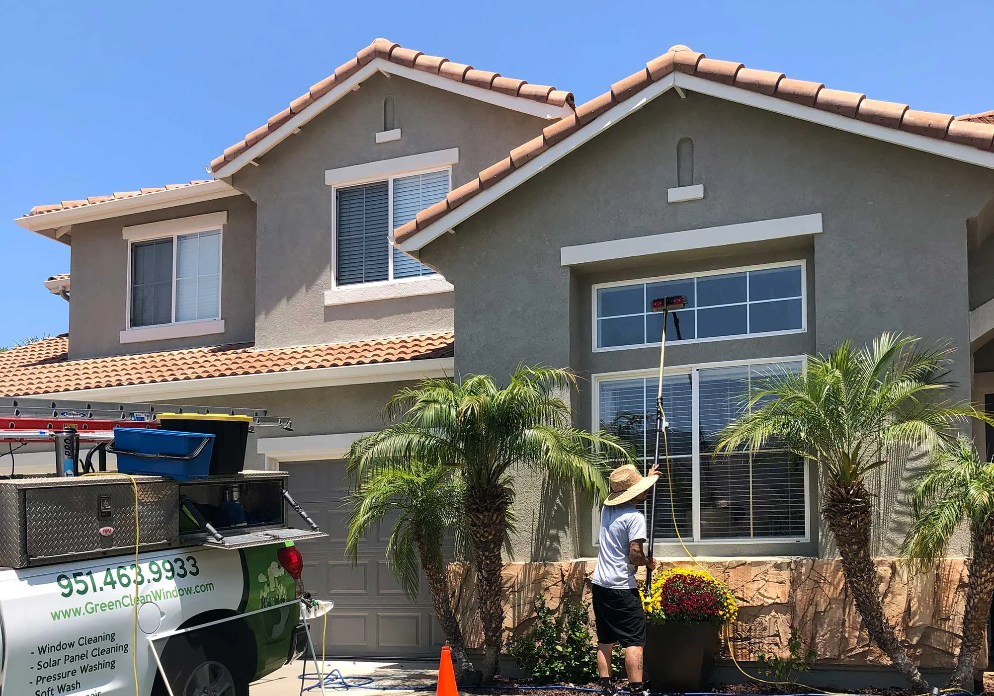 Professional window cleaning in progress with a water-fed pole in Corona, CA.