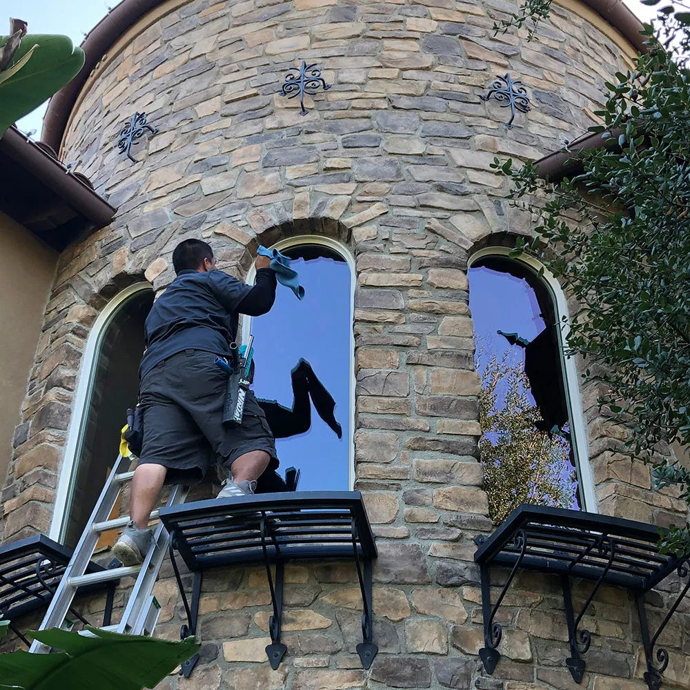 Green Clean Windows & Services Inc. team member cleaning the windows of a Corona home.