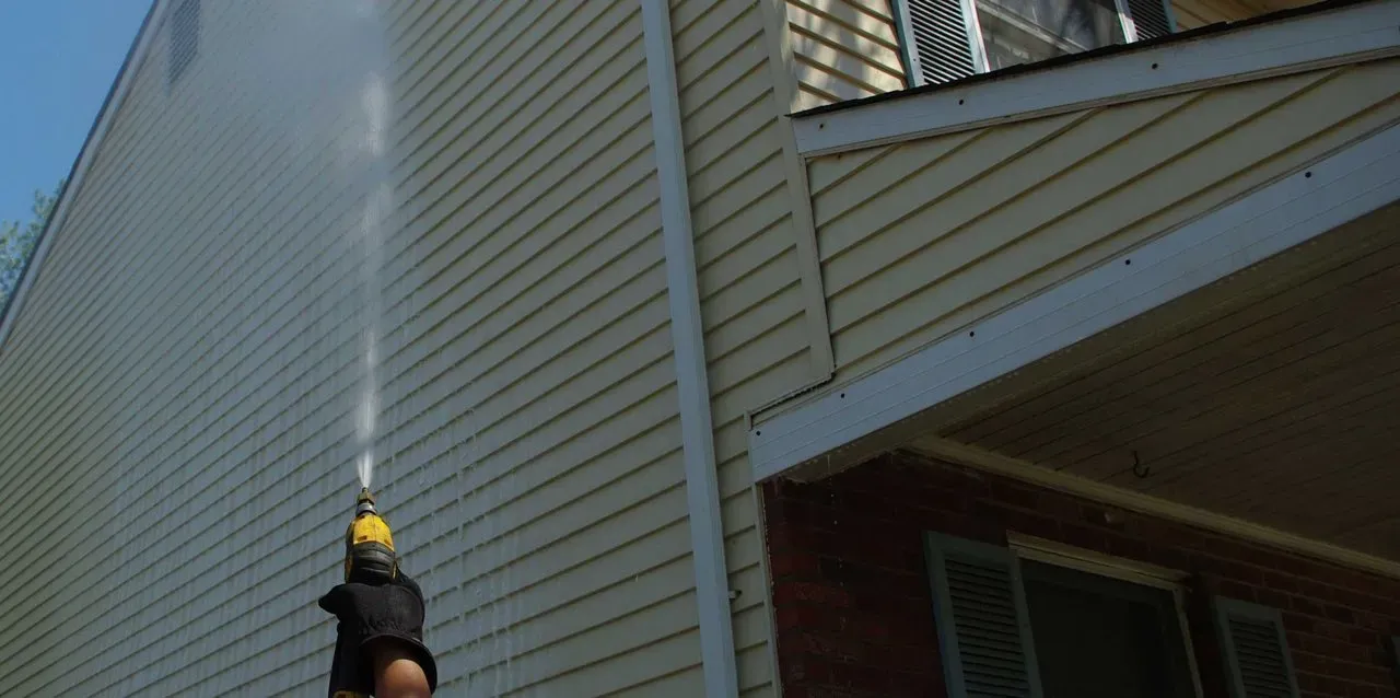 Pressure washing home siding in Calgary, AB.