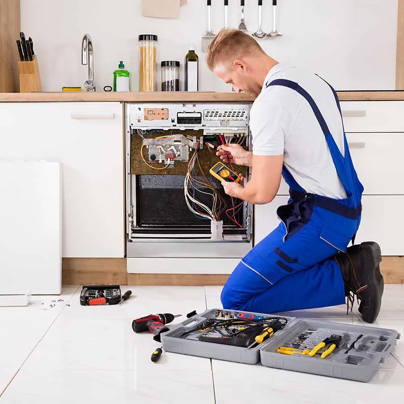Expert technician performing maintenance on a household appliance in Cambridge