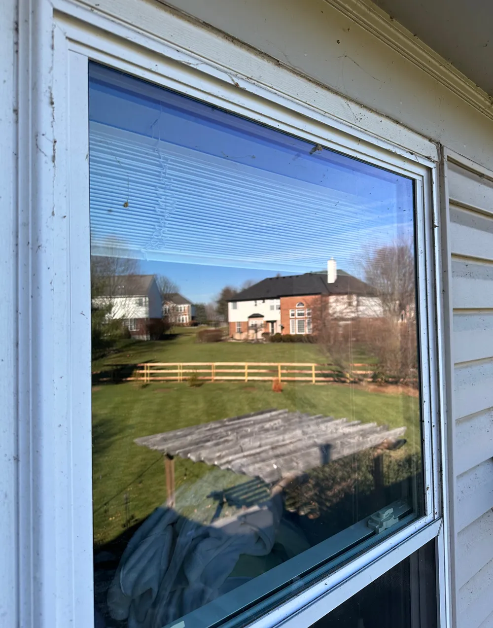 A dusty, spotted window in Loveland before Infiniti Glass's professional cleaning service.