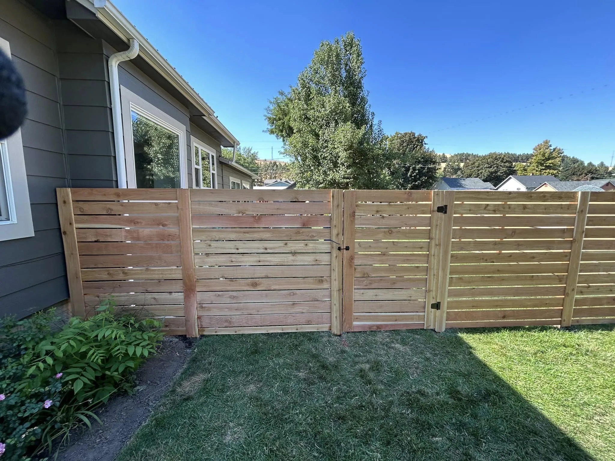 A newly installed, elegant fence by Fence-It Co. in Walla Walla, WA, providing privacy and elevating the home's exterior appeal.