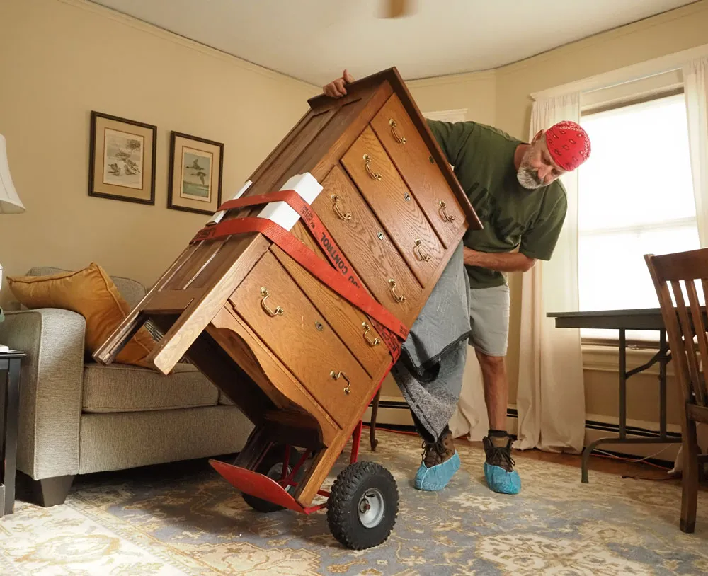 Professional team hauling carefully a dresser from a residential property in Charlottesville.