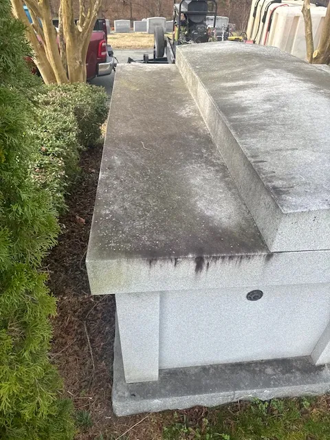Cemetery outdoor space with grime buildup before low pressure cleaning and concrete cleaning.