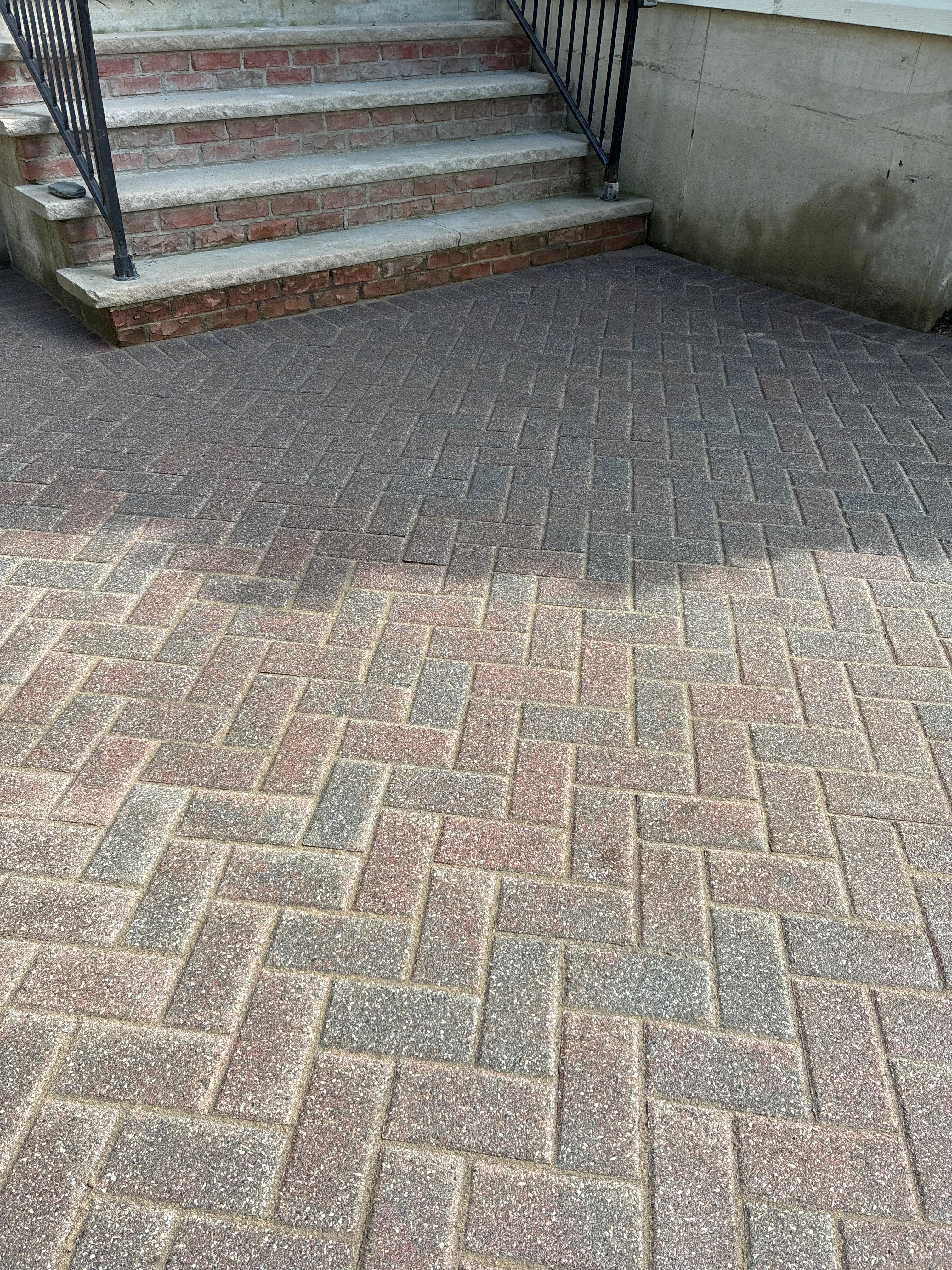 A green icon of a brick wall representing professional masonry and paver services.