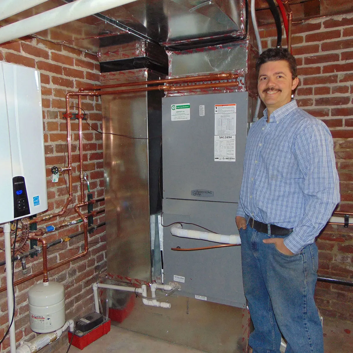 David Sutton, the owner of Cedar Creek Mechanical stood next to a new furnace and heater installation.