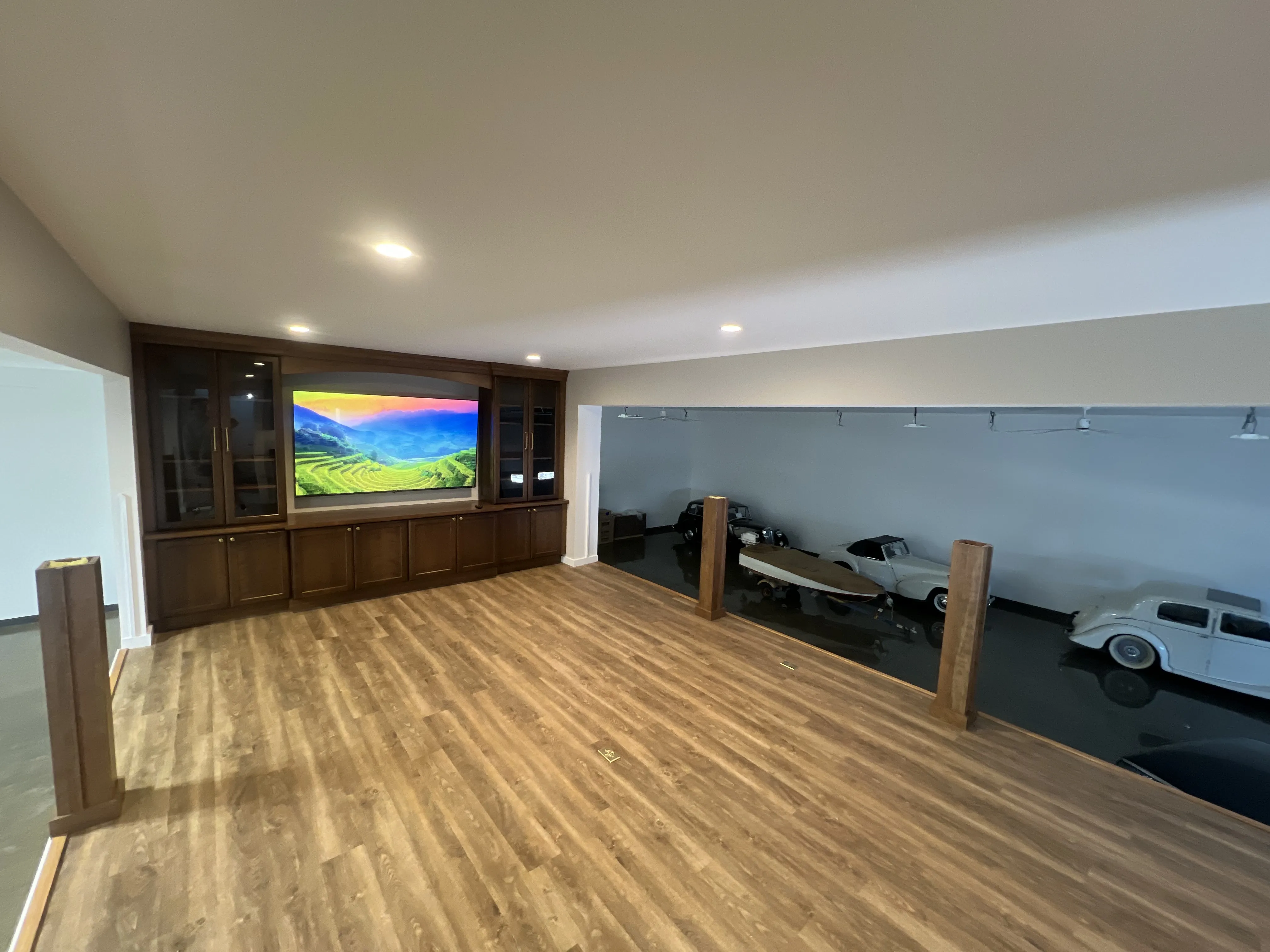 A beautifully painted modern living room featuring custom wood cabinetry, a large mounted TV, and sleek flooring, showcasing expert interior painting services.