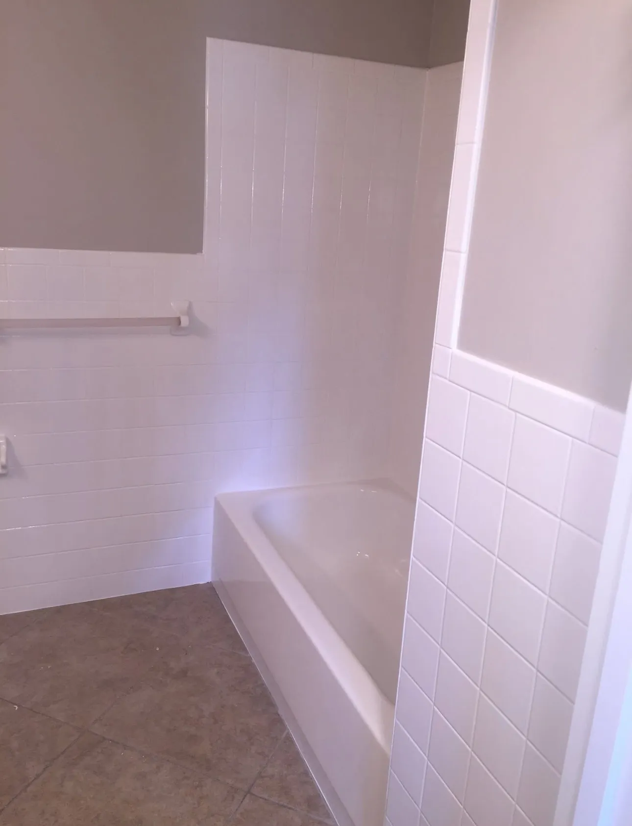 Technician using soft-wash equipment to clean a mossy concrete driveway in Winter Garden.