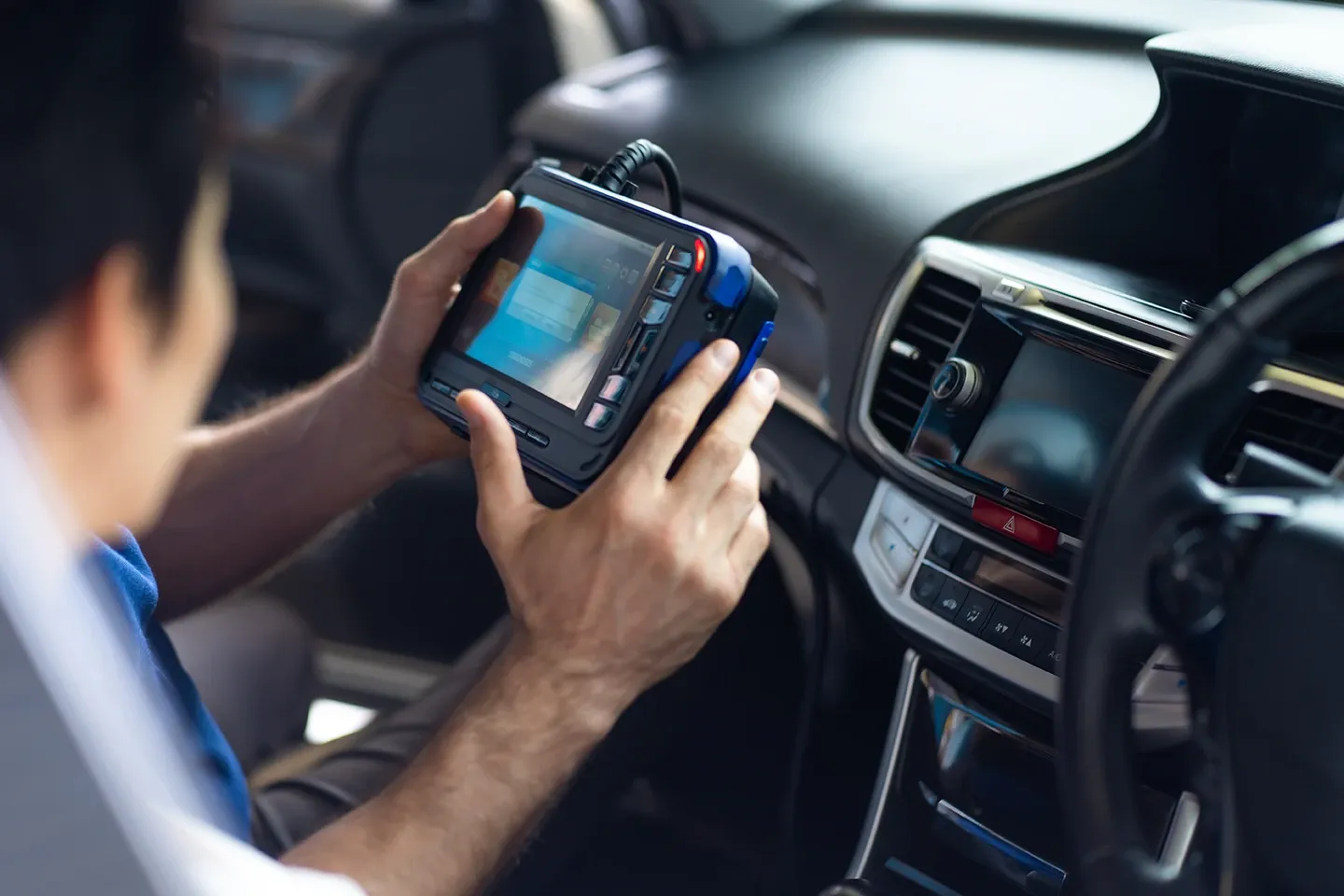 Mobile auto repair technician servicing a car’s control module in Waller, TX.