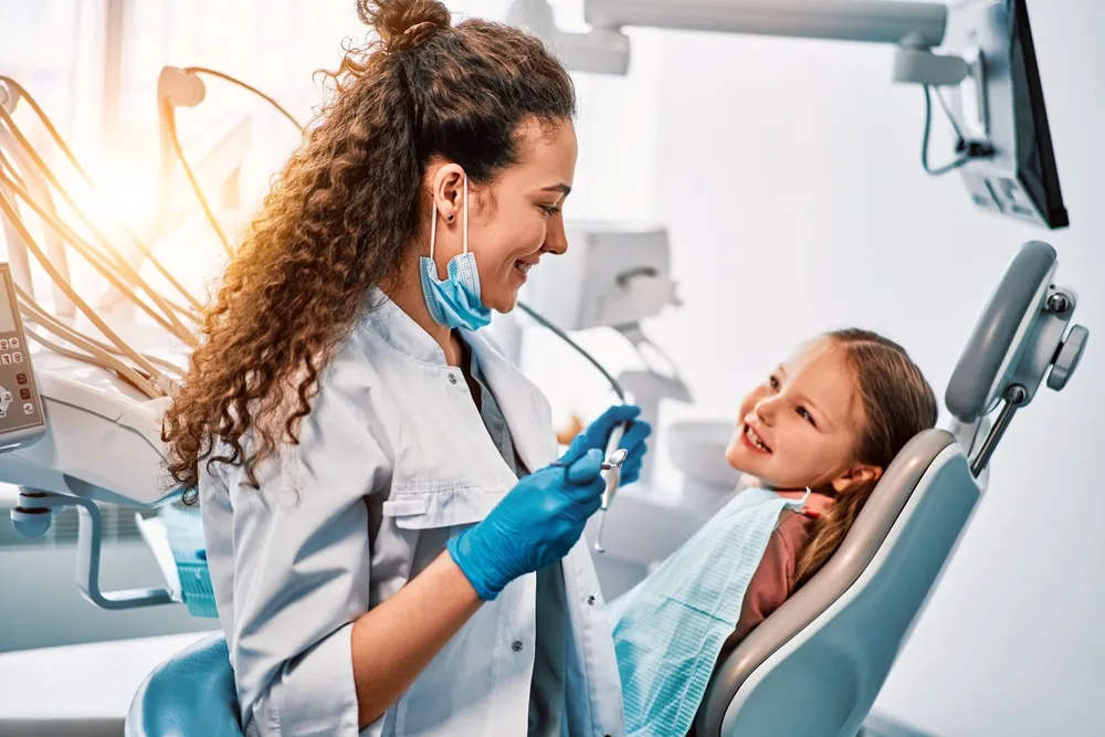 A dentist explaining health insurance coverage to a patient in Toronto. 