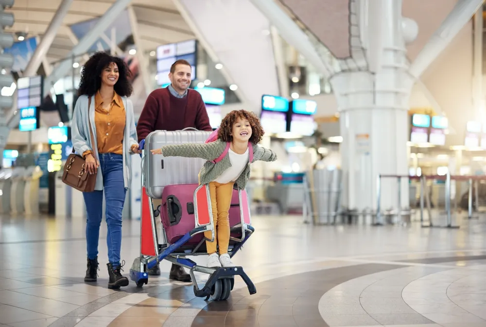 Family at the airport checking travel insurance details on their phone.