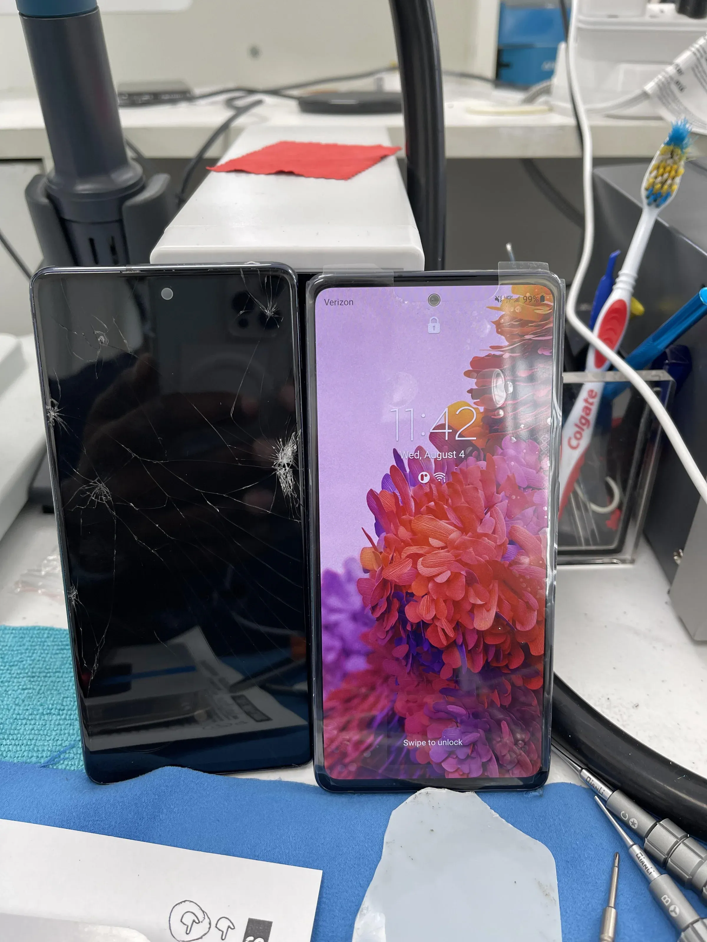 a phone wiht a broken  screen next to a phone with a normal screen