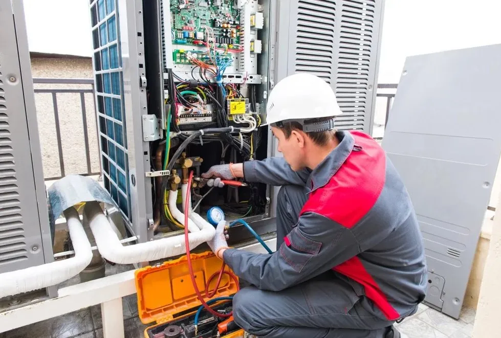 Technician performing ac repair and repair service on air conditioning system with hvac products, helping improve air quality in Chicago IL.