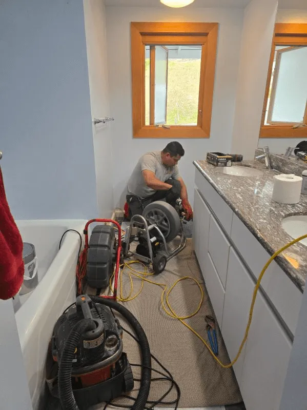 A professional drain specialist using a sewer camera inspection tool in a South Bay residence.