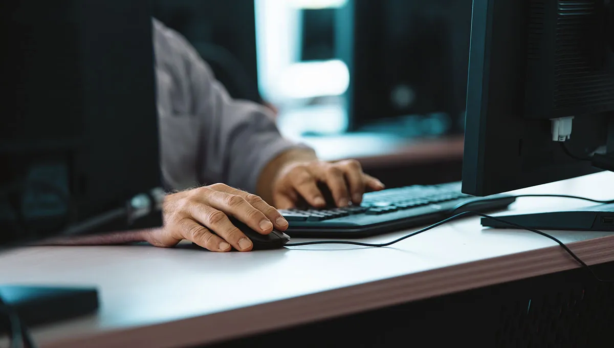 An IT professional working on a computer trying to diagnose the issue. 