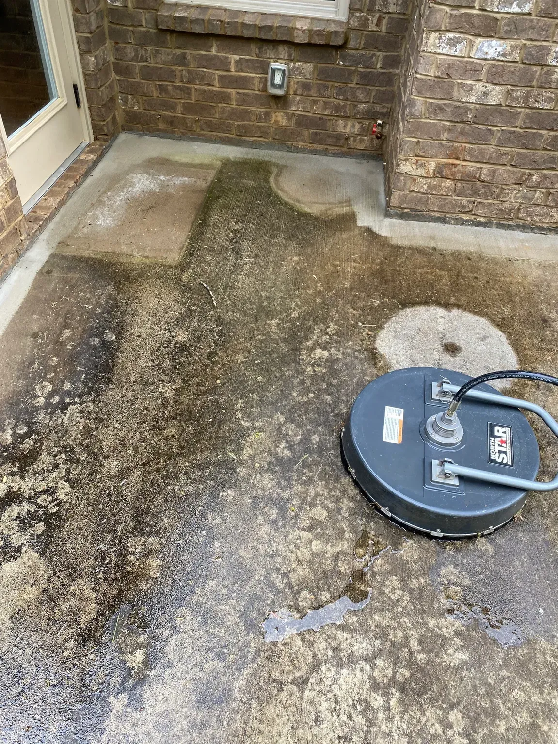 A clean and sanitized dumpster pad area behind a commercial restaurant.