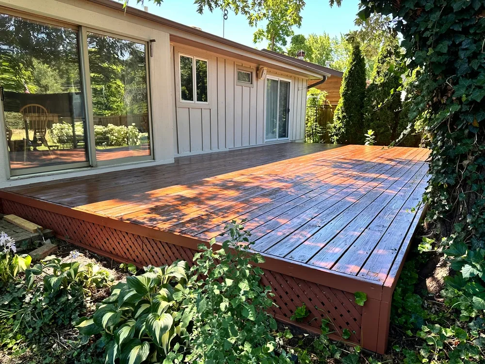 Luxury composite wood deck with black metal railings and built-in LED stair lighting.