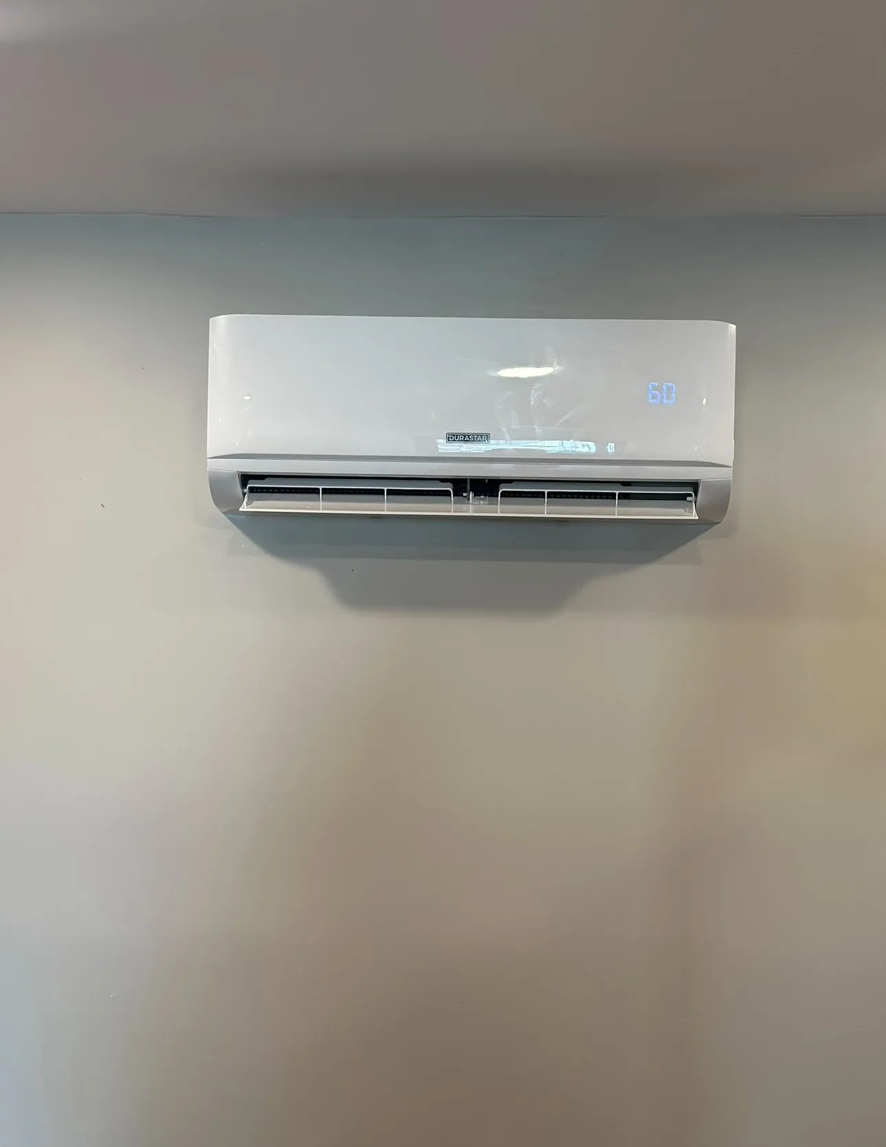 A technician uses an air quality monitor in an air conditioning unit to check for fine particles and perform AC repair services. 