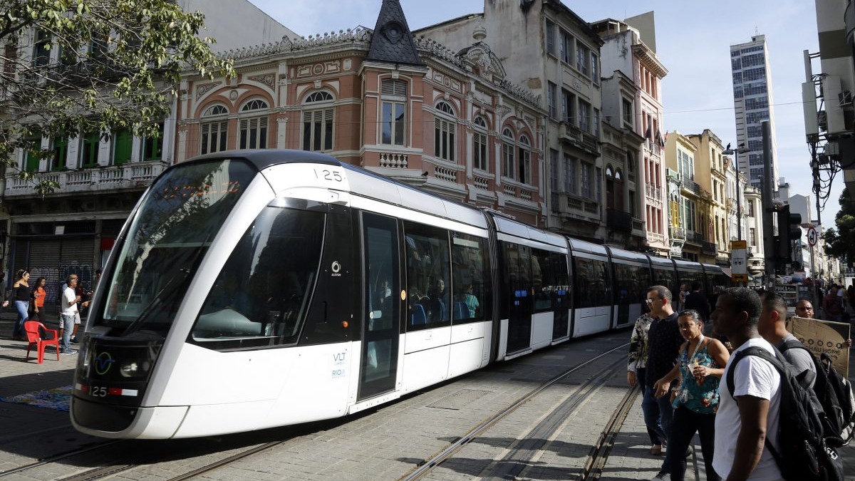 O VLT Carioca, que opera no Centro do Rio, terá esquema especial de funcionamento no feriado da Independência com alterações nas linhas. VLT branco e preto número 125, com passageiros, em rua movimentada do Centro do Rio