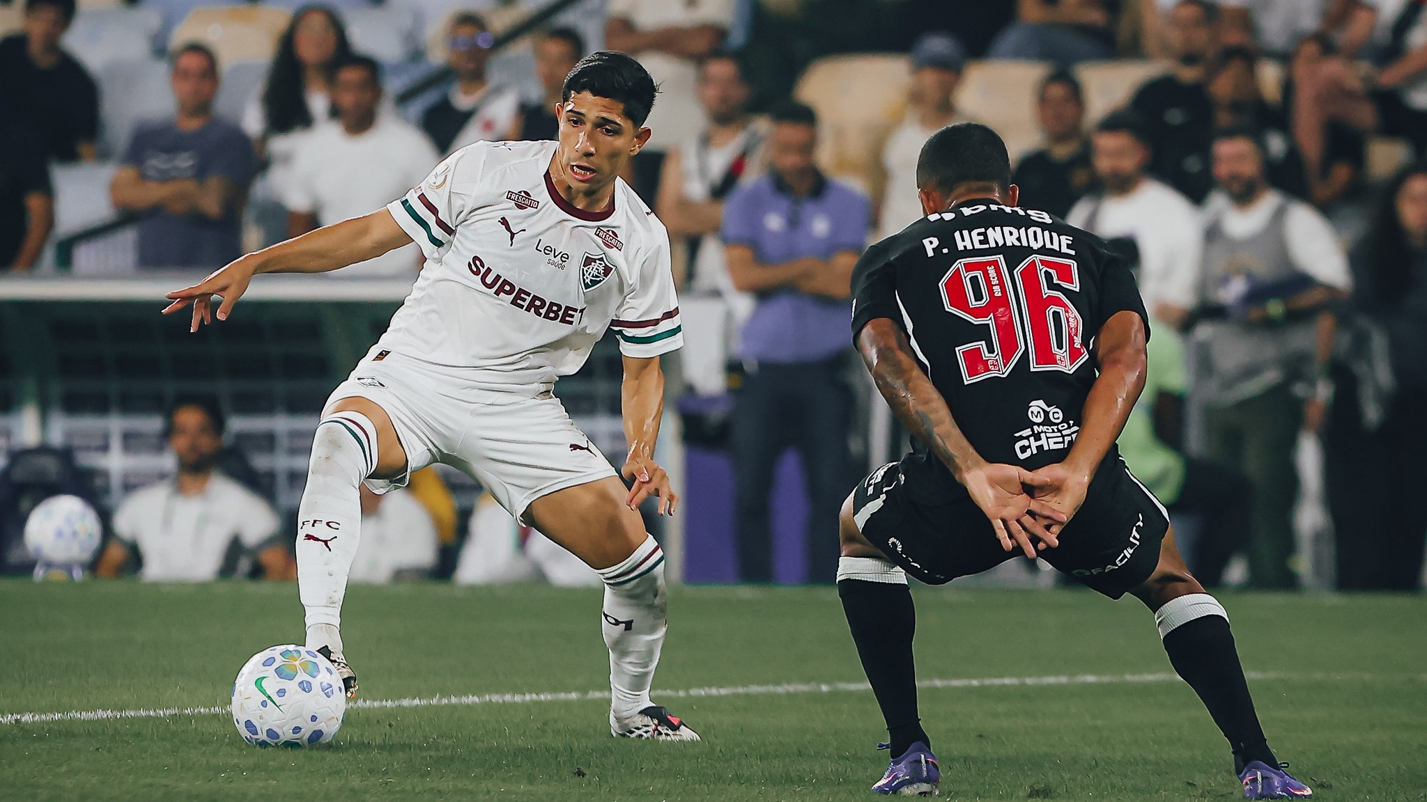 Expectativa alta para Fluminense e Vasco na Copa do Brasil, com Maracanã lotado para o jogo decisivo - FOTO: LUCAS MERÇON / FLUMINENSE F.C.
Dois jogadores de futebol em campo. Um branco com bola, outro preto com P. HENRIQUE 96