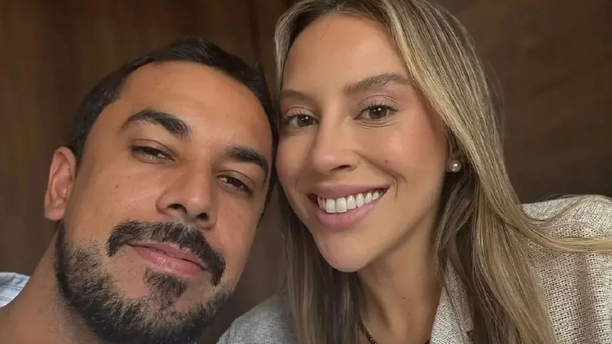 Maike, que comentou sua harmonização facial, aparece em foto com a namorada Renata Saldanha, campeã do BBB 25, com quem planeja casamento. Close-up de casal: homem com barba e mulher loira sorrindo para a câmera