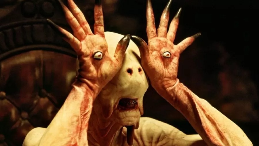 "O Labirinto do Fauno" é um dos filmes destacados na lista de produções ideais para assistir nos dias de frio em casa. Criatura pálida com olhos nas palmas das mãos erguidas e garras longas, boca aberta.