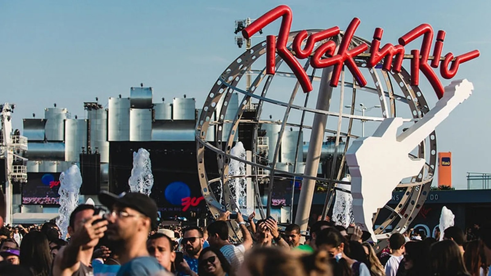 O Rock in Rio se prepara para receber o público com shows e um esquema especial de transporte. Vista do Rock in Rio com o letreiro vermelho, globo, guitarra branca e multidão animada