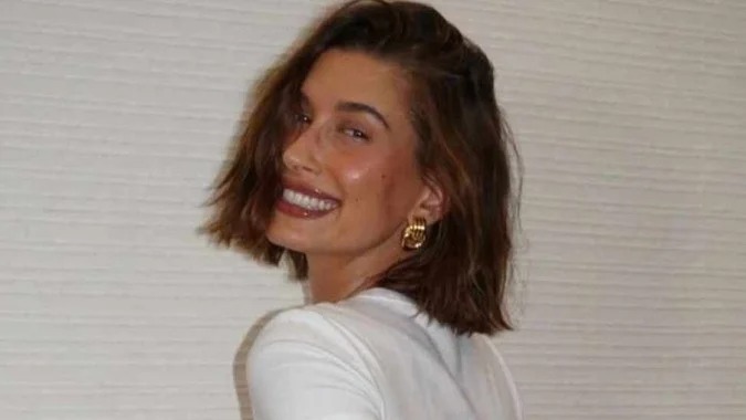O Italian Bob oferece volume e movimento, sendo uma das tendências capilares em destaque para renovar o visual. Mulher sorrindo com cabelo castanho estilo Italian Bob e brincos dourados.