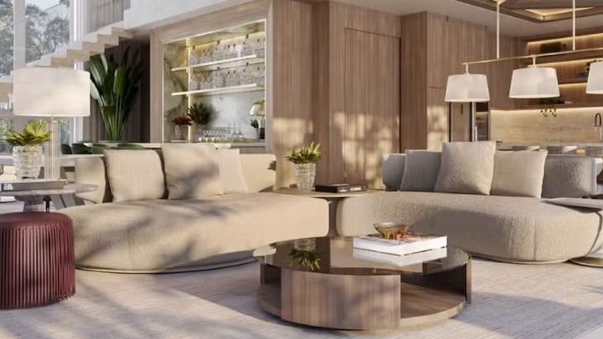 Sala de estar moderna e luxuosa com dois sofás arredondados, mesa de centro e bar integrado