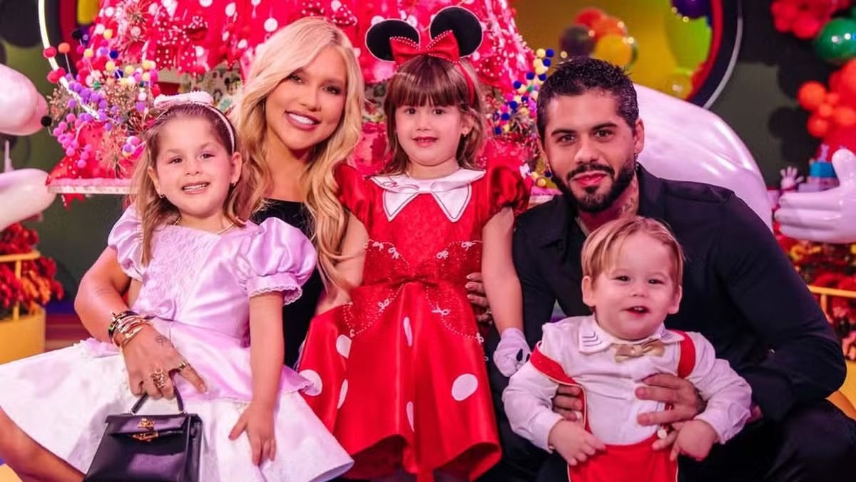 Virginia Fonseca, Zé Felipe e seus filhos, que viveram na mansão milionária agora à venda em Goiânia. Virginia Fonseca, Zé Felipe e três filhos sorrindo em ambiente festivo com tema infantil