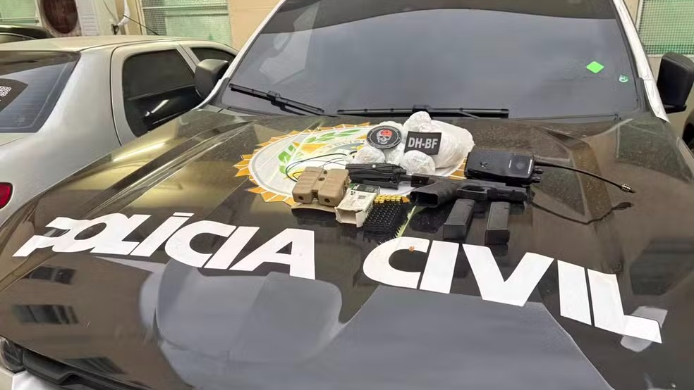 Material apreendido pela Polícia Civil durante operação no Complexo do Muquiço que visava prender assassinos de inspetor. Pistola, carregadores, munições, drogas e rádio comunicador em capô de viatura da Polícia Civil