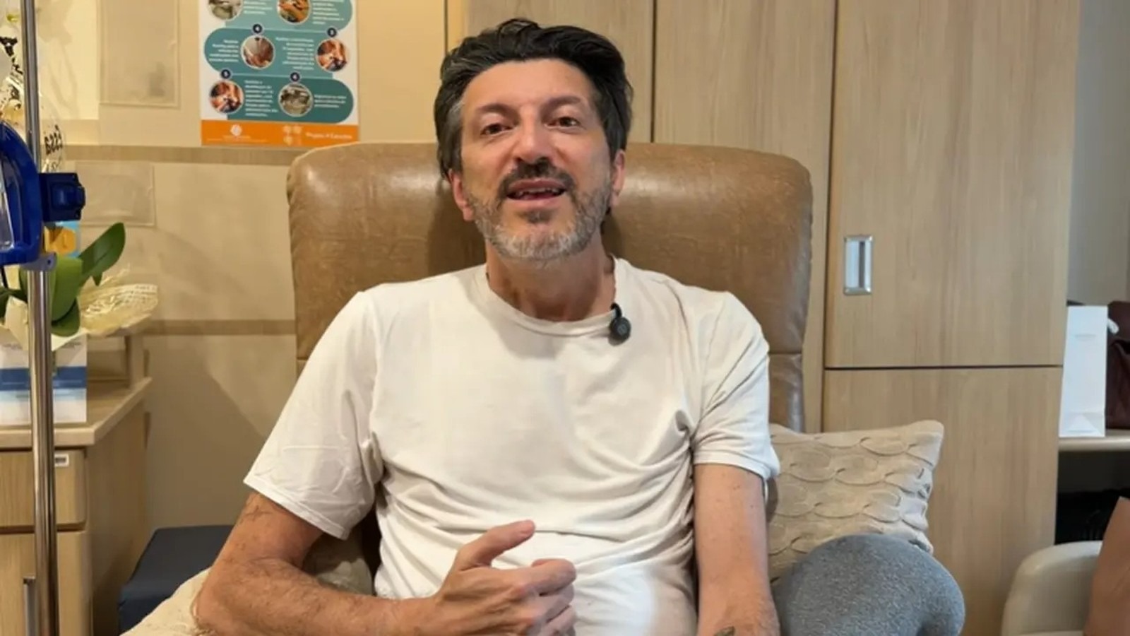 Lito Sousa, especialista em aviação, em um dos momentos de seu tratamento contra a doença de Creutzfeldt-Jakob. Homem de barba, camisa branca, sentado em cadeira, com suporte de soro ao lado