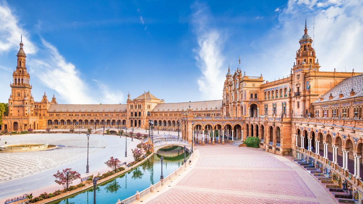 Pra&ccedil;a de Espanha, Sevilha: edif&iacute;cio grandioso, canal, pontes, arcos, c&eacute;u azul.