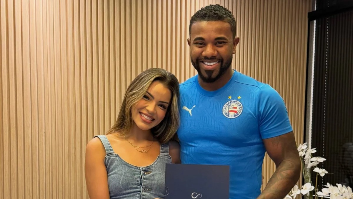 Davi Brito e Emilly Araujo em foto do anúncio do casamento civil, conforme divulgado na semana. Foto: Reprodução/Instagram Davi Brito e Emilly Araujo sorriem, ela segura documento, ele veste camisa de time