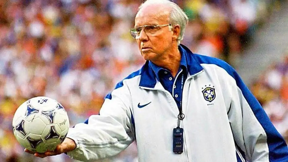 Mário Jorge Lobo Zagallo, figura central de uma disputa judicial por sua herança, em imagem que remete à sua icônica trajetória no futebol brasileiro Mário Jorge Lobo Zagallo de óculos e jaqueta da seleção brasileira, segurando uma bola de futebol