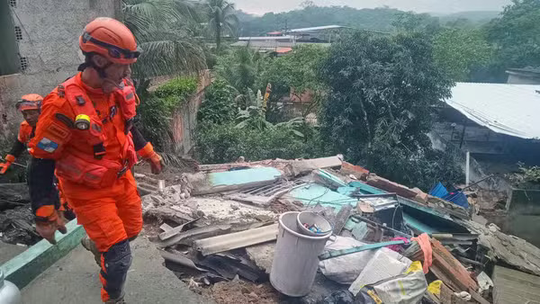 Bombeiros no local do desabamento em Niterói, onde dois irmãos foram resgatados dos escombros pela manhã - Foto: Divulgação/CBMERJ Bombeiro em uniforme laranja e capacete laranja caminhando sobre escombros de desabamento em área verde