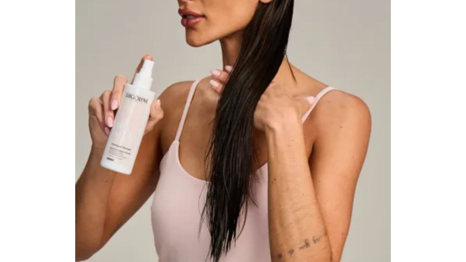 Mulher aplica spray Rigolim Thermal Dream Protector T&eacute;rmico em cabelo molhado, frasco branco