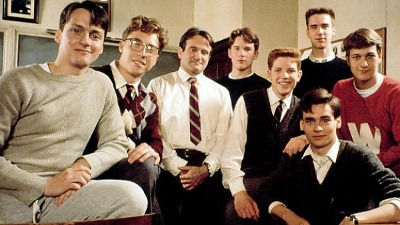Robin Williams e o elenco de 'Sociedade dos Poetas Mortos', um clássico drama escolar para aquecer os dias frios. Nove homens posando e sorrindo, um mais velho de gravata, e oito jovens estudantes.