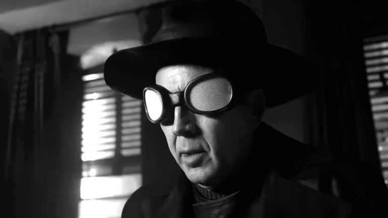 Nicolas Cage como Spider-Noir, personagem que protagoniza a série do Prime Video com estética inspirada no cinema noir dos anos 30 e 40. Nicolas Cage como Spider-Noir, de chapéu e óculos, em cena de close-up em preto e branco.